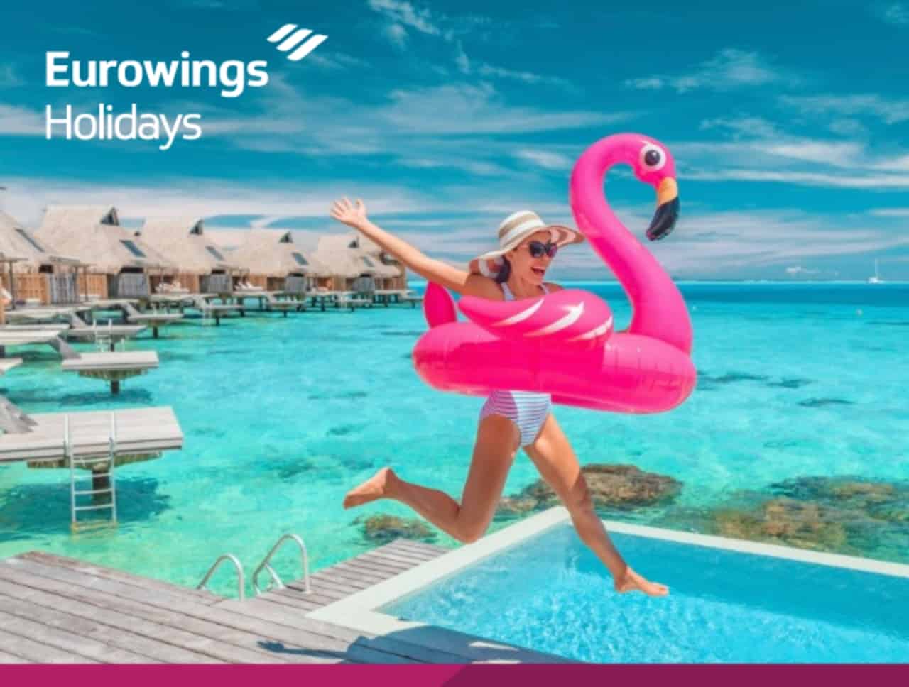 Eine Frau mit einem pinken Flamingo-Schwimmreifen springt gut gelaunt in einen Swimmingpool. Jetzt Angebote entdecken.