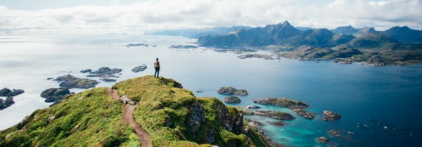 Man steht auf einem HÃ¼gel und blickt Ã¼ber einen Fjord.
