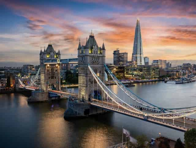 Blick auf die Tower Bridge und die dahinterliegende Skyline von London in der Abenddämmerung – jetzt Citytrip buchen und mit unseren Aktionscodes sparen!