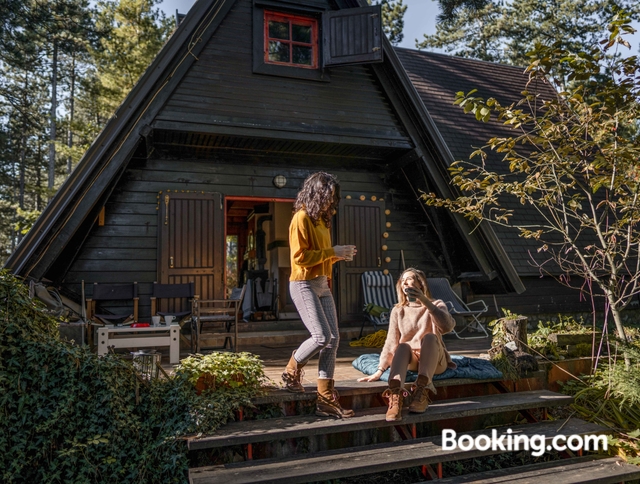 Zwei Frauen sitzen vor einem Holzhause. Jetzt bis zu 35 % Ã¼ber Booking.com sparen